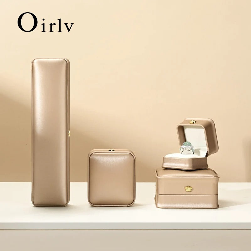 Set of gold jewelry boxes with 'Oirlv' branding on a beige background