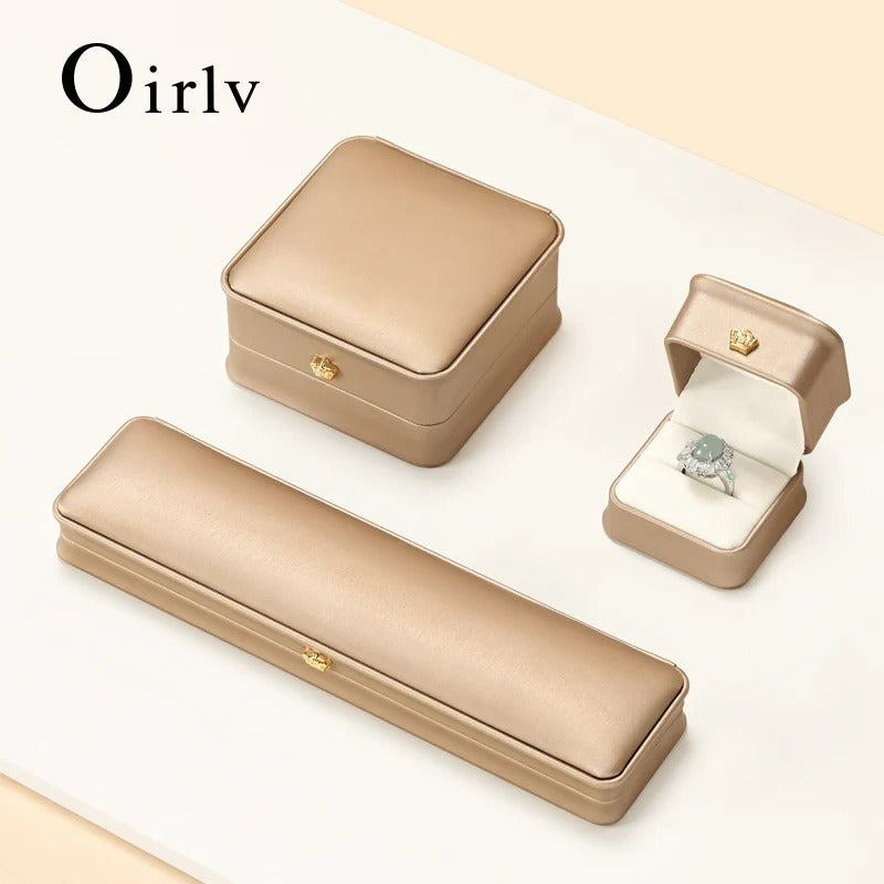 Beige jewelry box set with a ring on a light beige background, featuring the brand 'Oirlv'.
